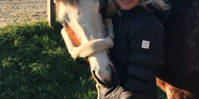 Frau mit blonden Haaren und Pferd mit blauen Augen