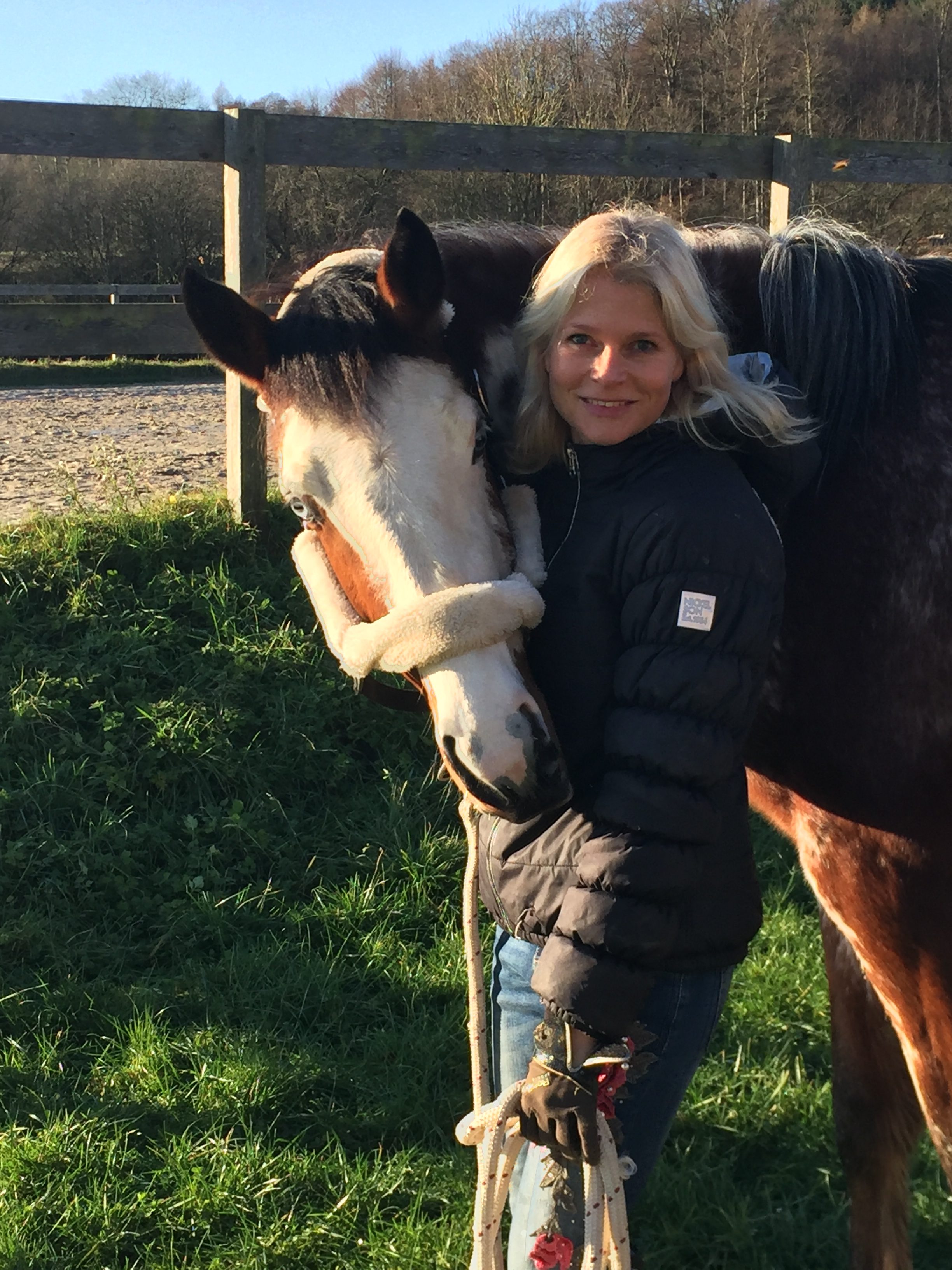 Frau mit blonden Haaren und Pferd mit blauen Augen